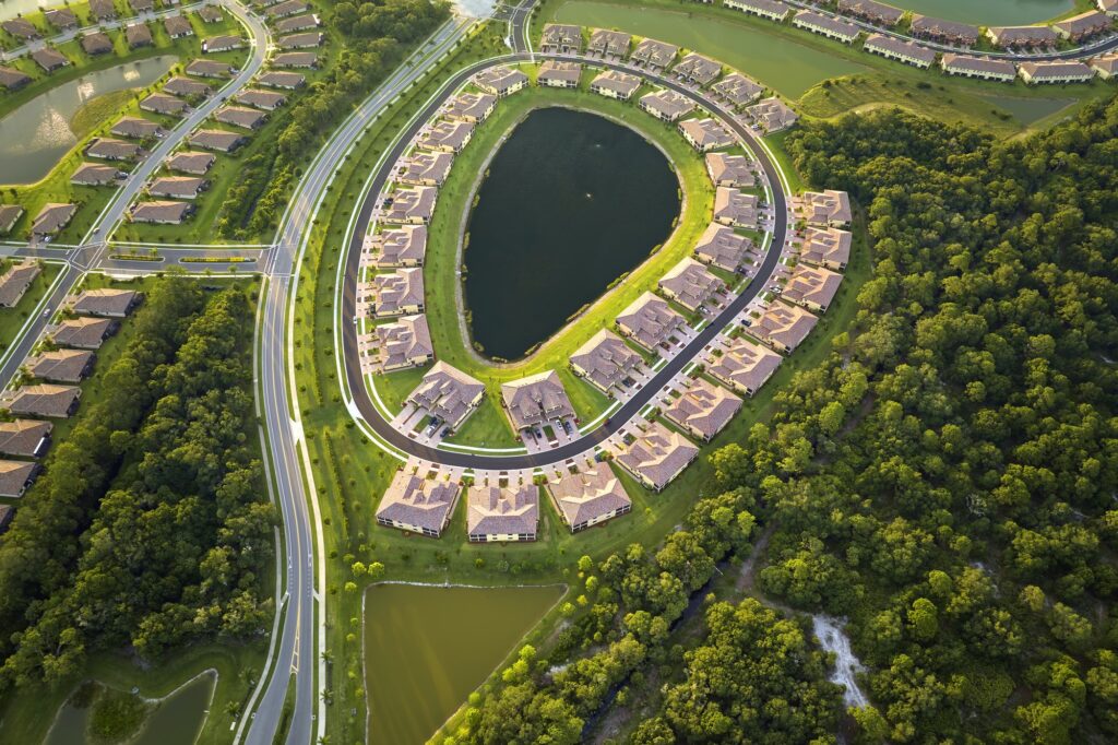 Aerial view of tightly located family houses with retention ponds to prevent flooding in Florida
