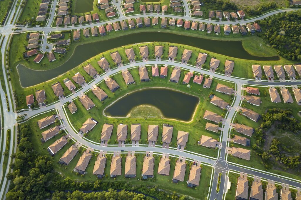 Aerial view of tightly located family houses with retention ponds to prevent flooding in Florida