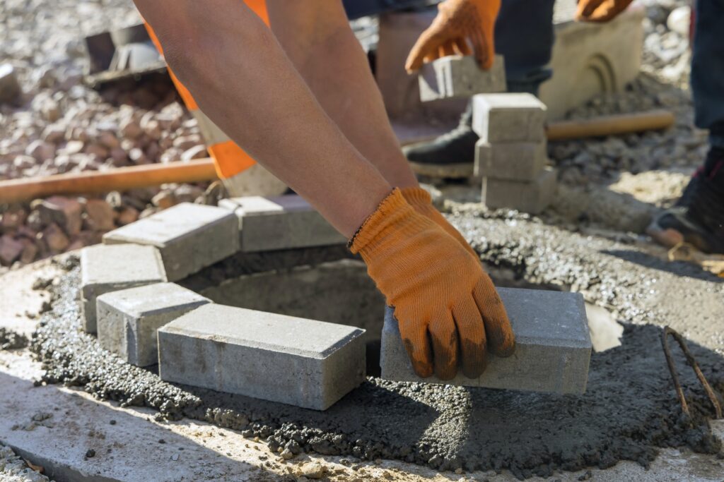 Utility worker installing manhole sewage reconstruction a pit for a septic tank