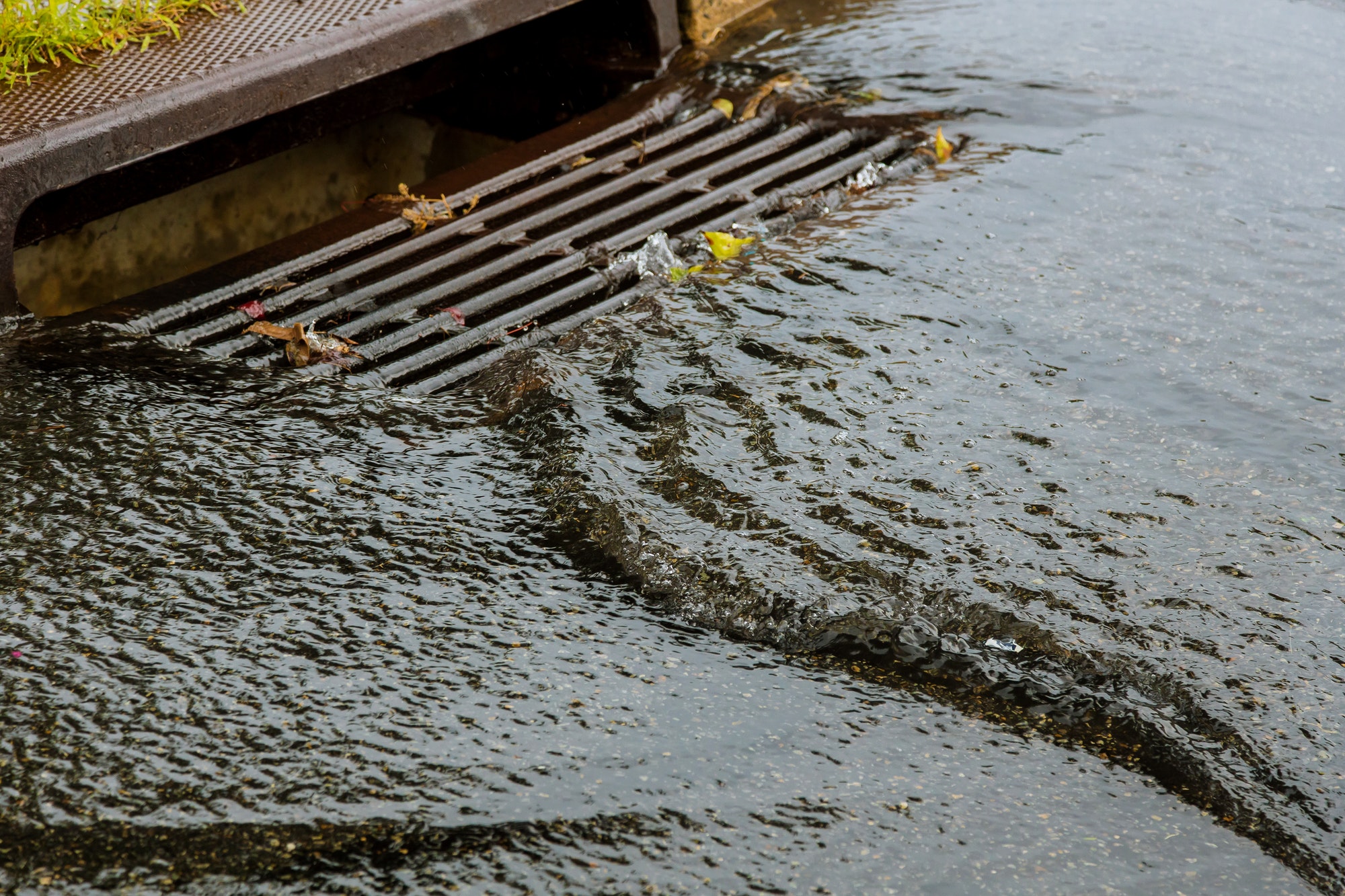 Water gushing from storm sewer following very heavy rainfall of the road after heavy rain.